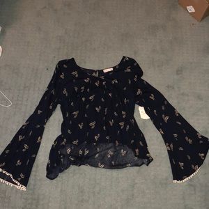 Black top with yellow feather design on it